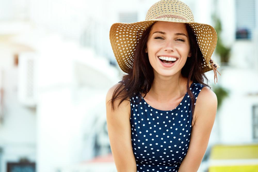 woman in a sun hat smiling after cosmetic dentistry in Apex, NC.
