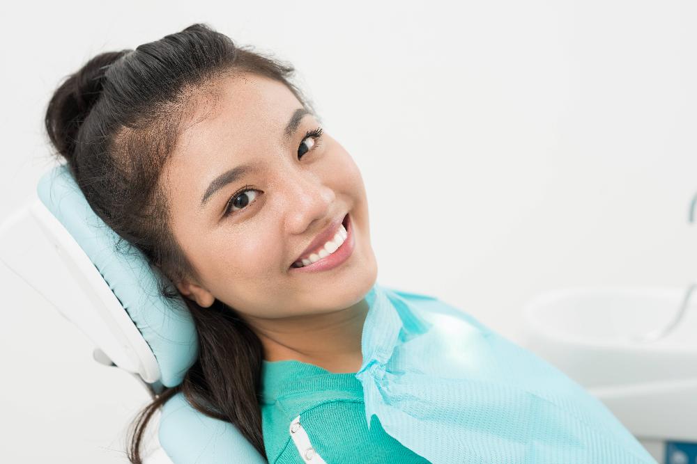 woman smiling in dental chair before dental cleaning in apex