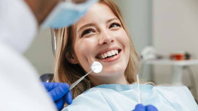 woman smiling during dental cleaning in apex nc