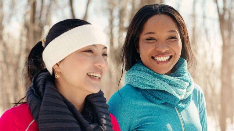 two women walking in a park in the snow