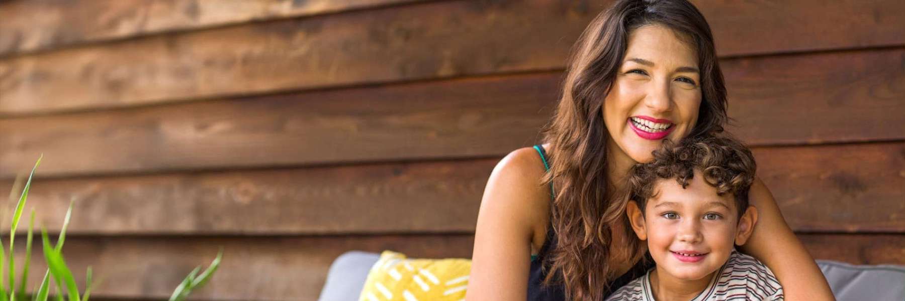 A smiling mother and her son sitting on the patio