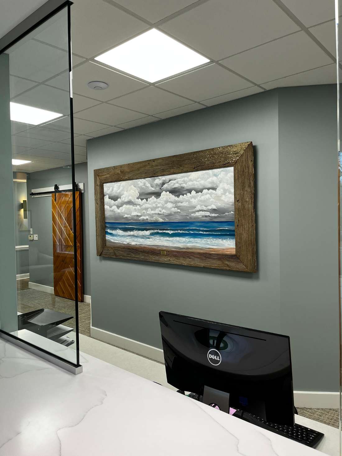Front desk with a painting of the ocean behind it