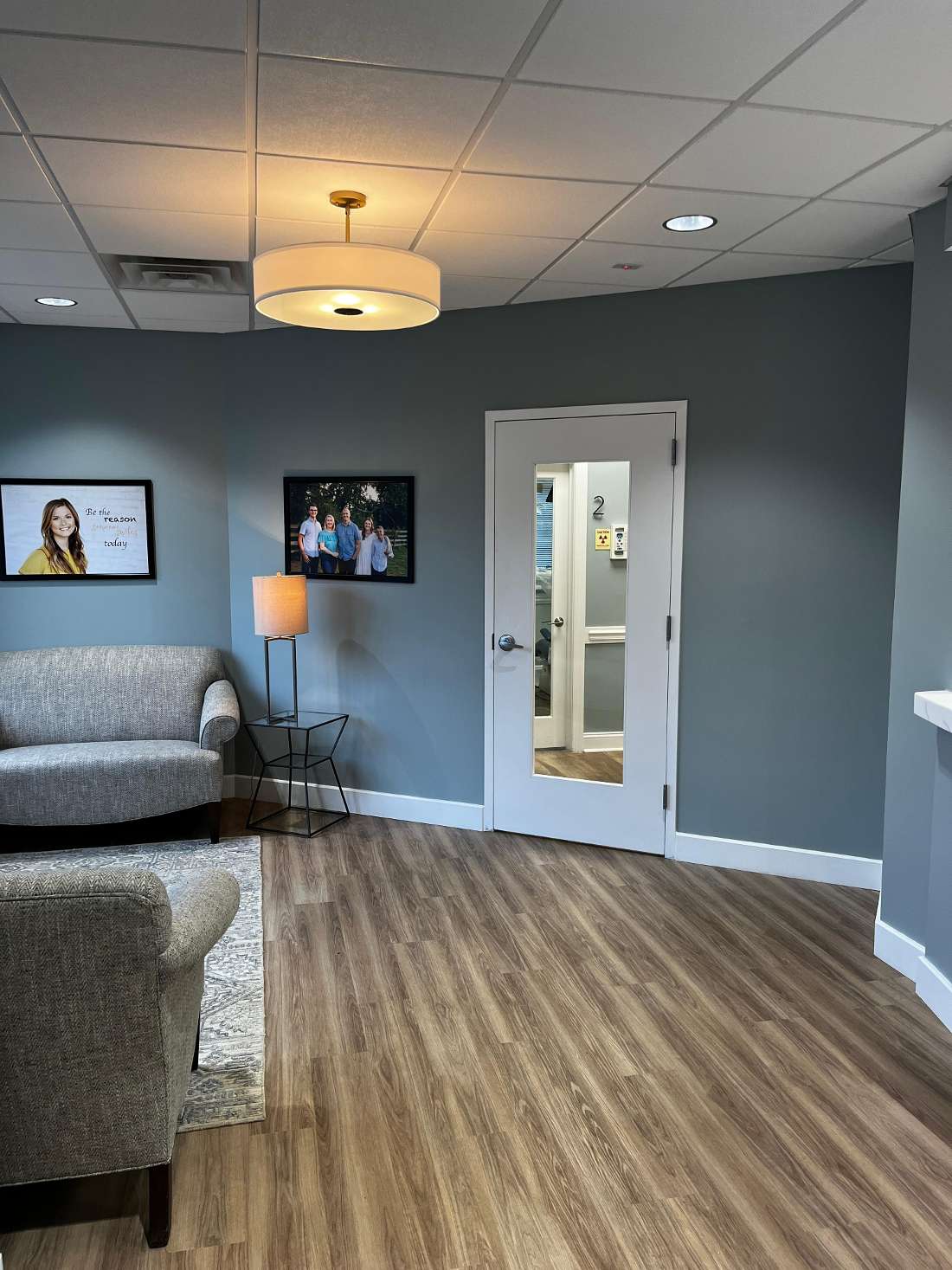 modern and comfortable front lobby with wood floors and grey couches