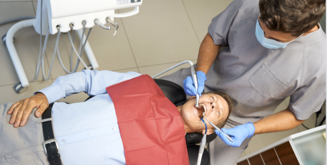 Dentist examining an adult patient in a dental chair