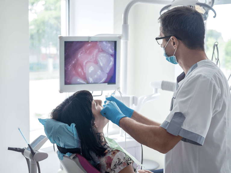 Dentist using an intraoral camera to show a patient a close-up view of a tooth