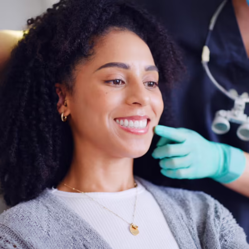 Smiling WomWoman smiling while looking at her teeth in a mirror an Examining Her Teeth
