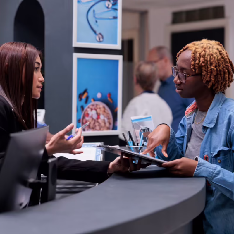 Patient speaking with a dental receptionist at check-in