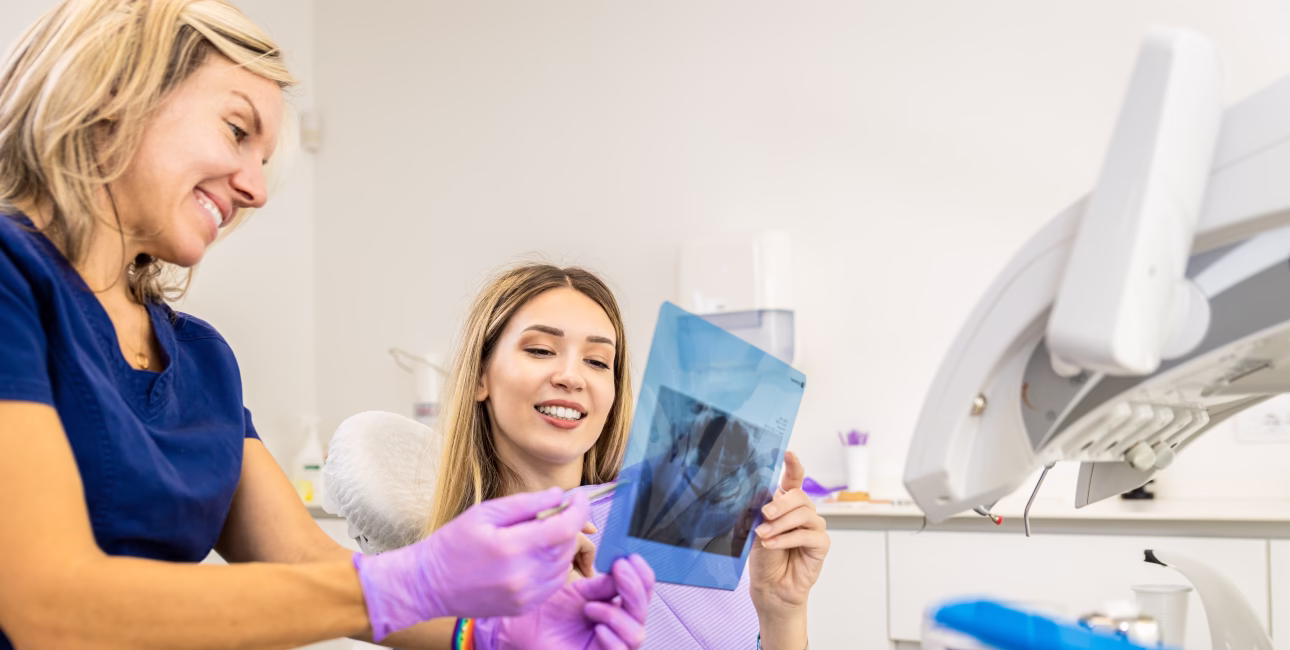 Dental professional reviewing a dental X-ray with a patient