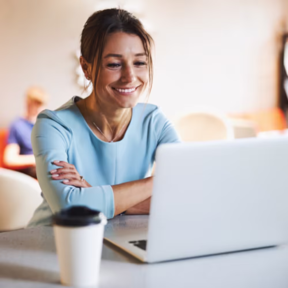 Woman smiling while using a laptop